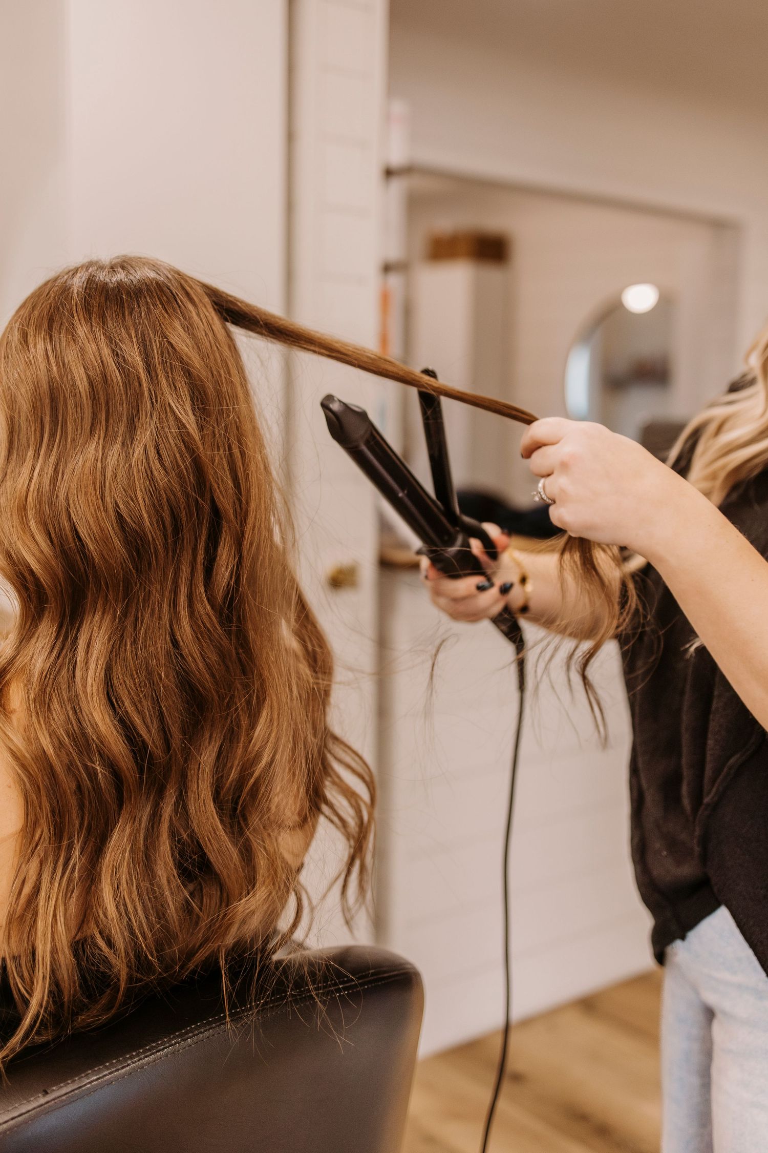 Hair styling demonstration showing use of flat iron on medium length hair.