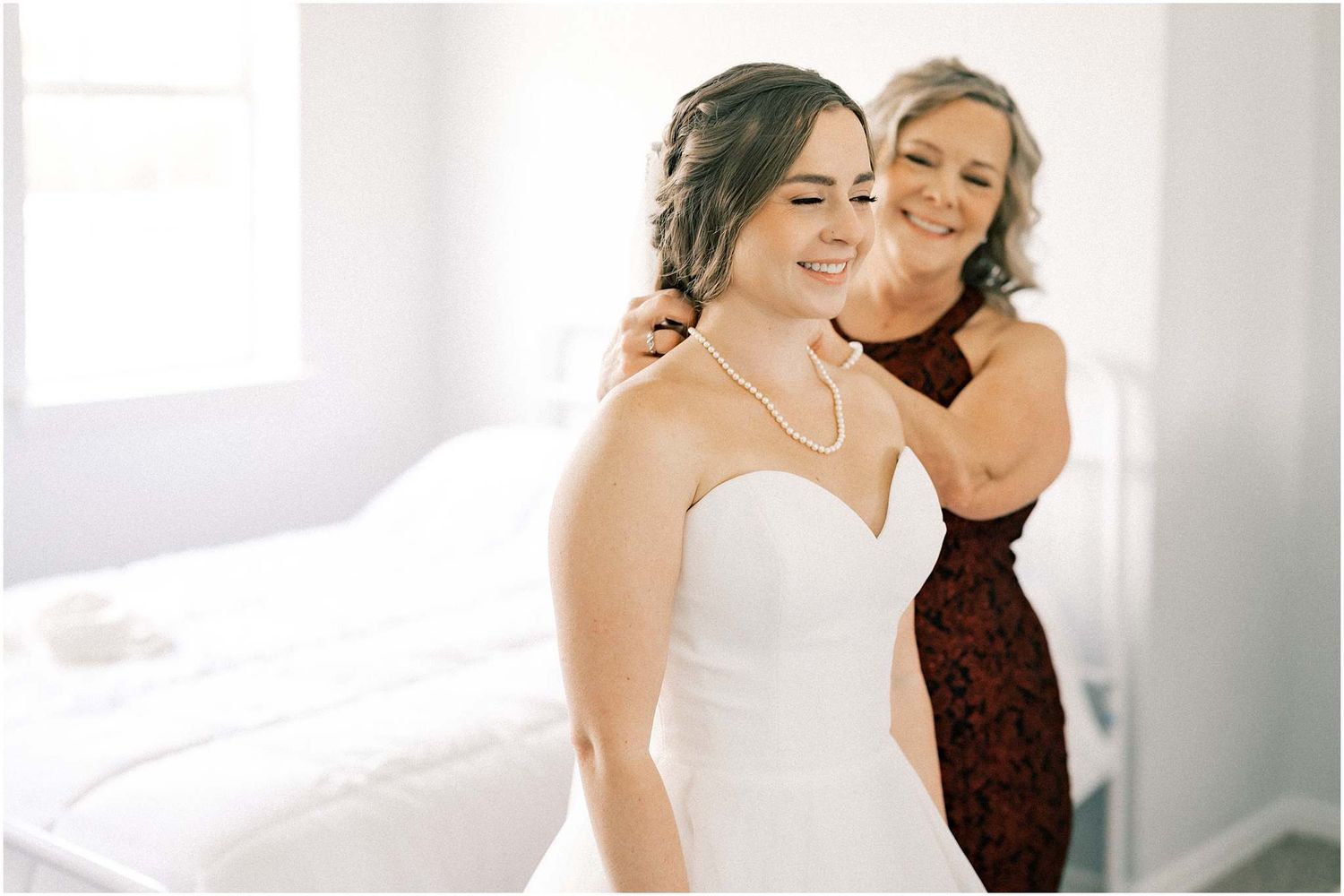 Wedding dress being adjusted in a bright sunlit room.