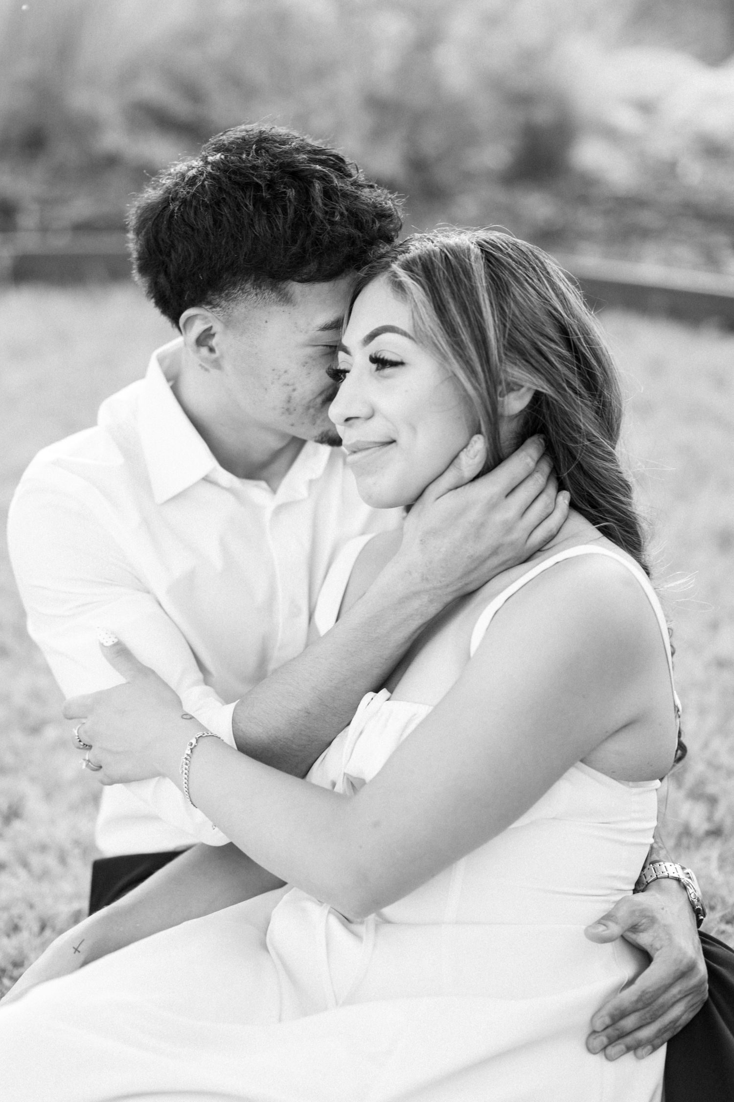 Black and white portrait of a couple sharing an intimate embrace during engagement session.