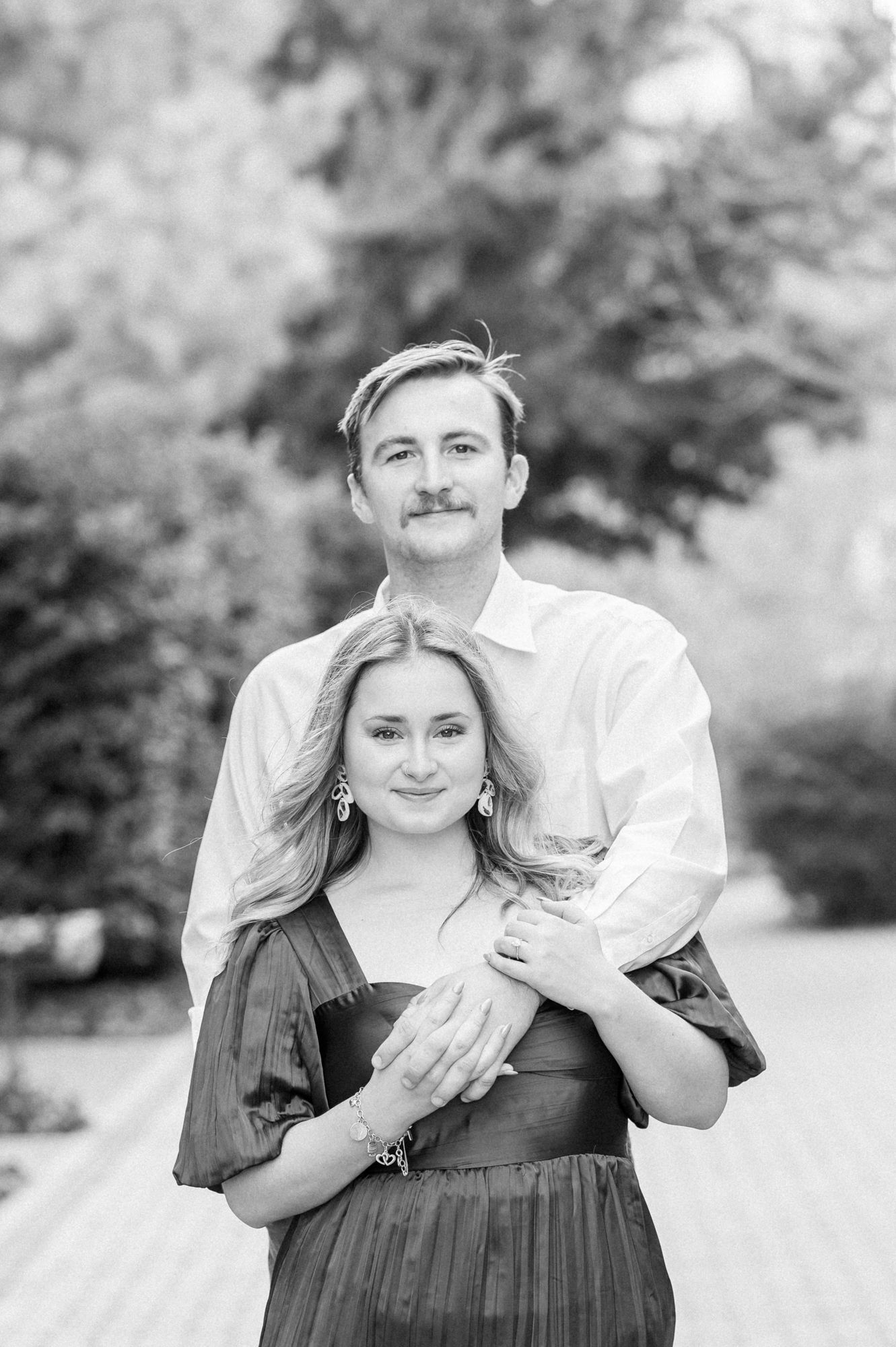Black and white portraits of couple embracing and smiling together outdoors.