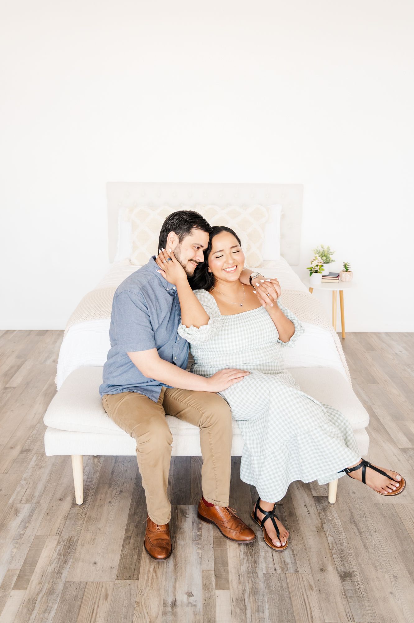 An intimate portrait of a couple sharing laughter on a white bench.