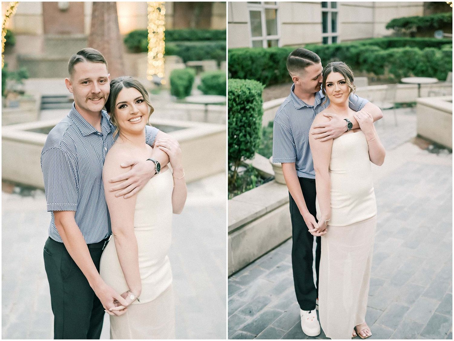 A couple embraces while posing for engagement photos on a brick pathway near a classic building exterior.