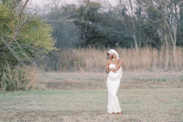 A dreamy outdoor photoshoot featuring a flowing white dress against a rustic natural landscape.