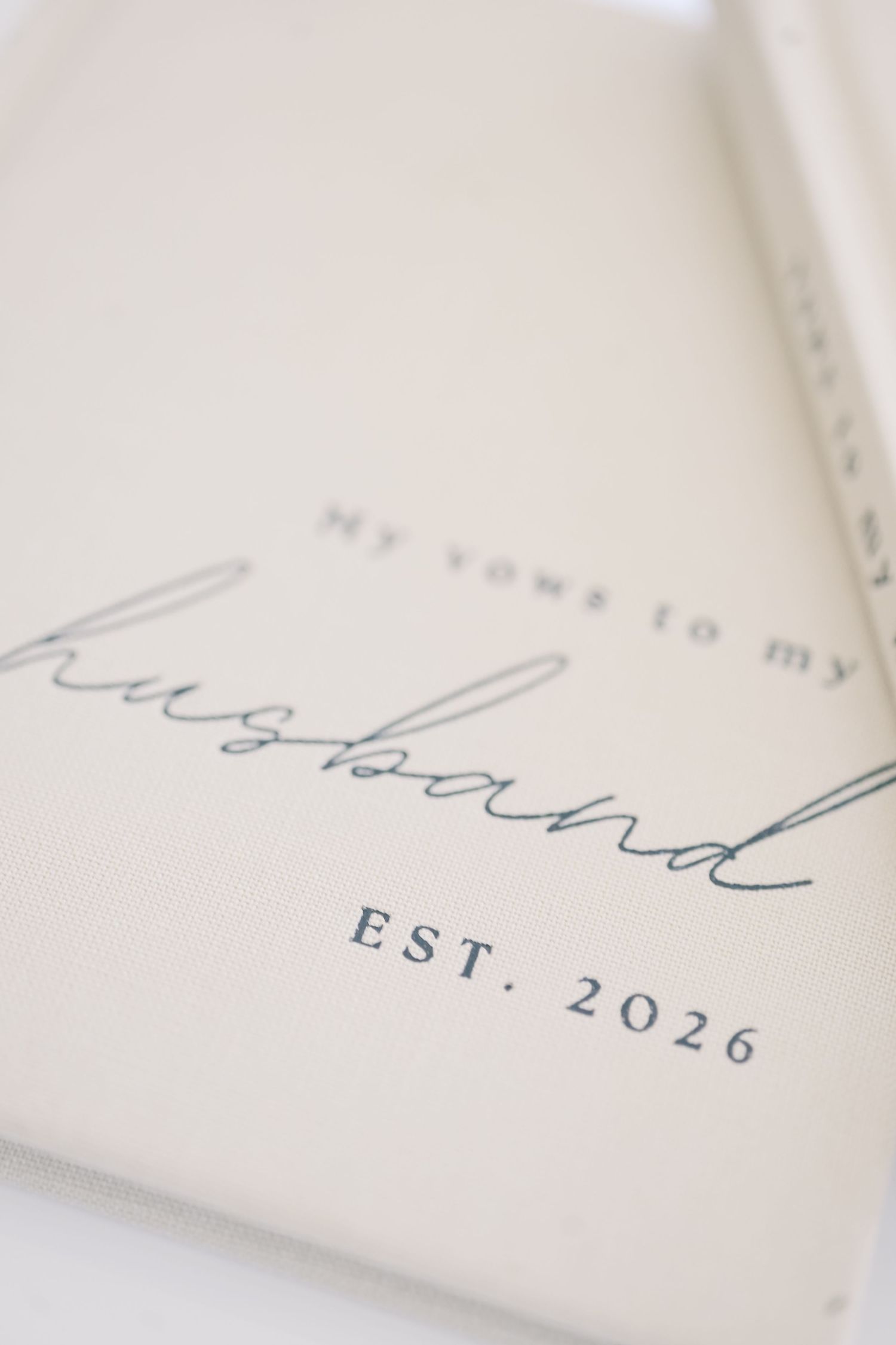 Elegant white vow book reading my vows to my husband EST. 2026 in navy script lettering.