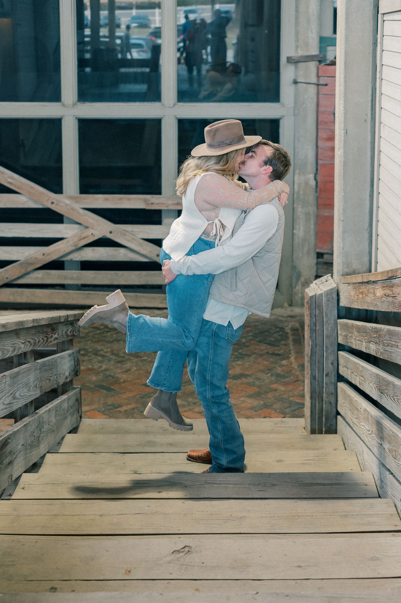 Couple sharing a playful dance sequence on a wooden deck with western-style clothing.