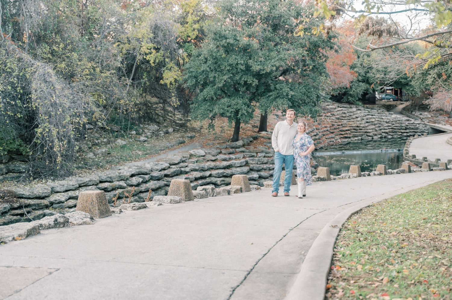 Natural outdoor portrait session with stone path and lush greenery surrounding a rustic barn setting.