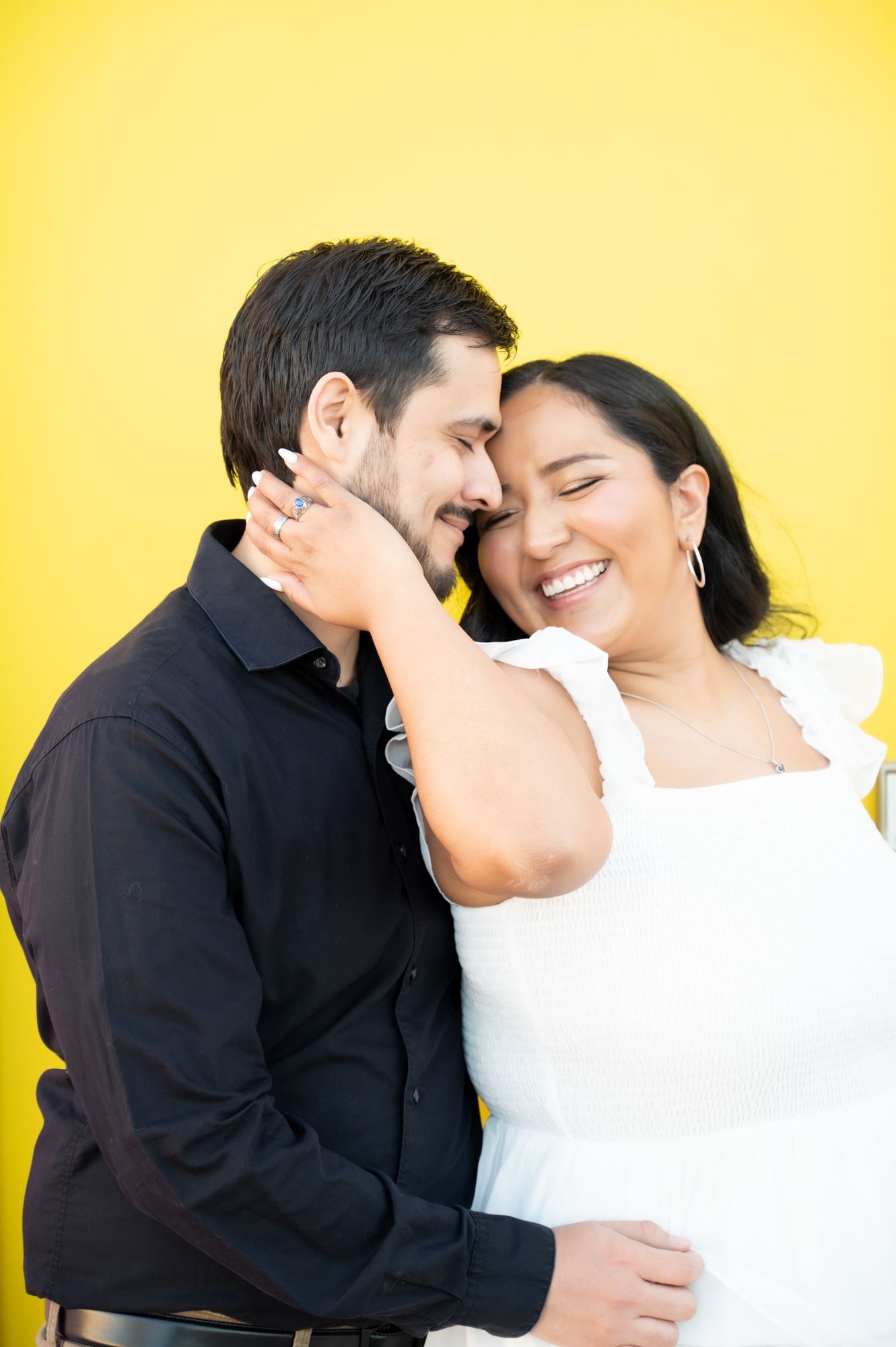 Romantic couple sharing an intimate moment against a bright yellow background.
