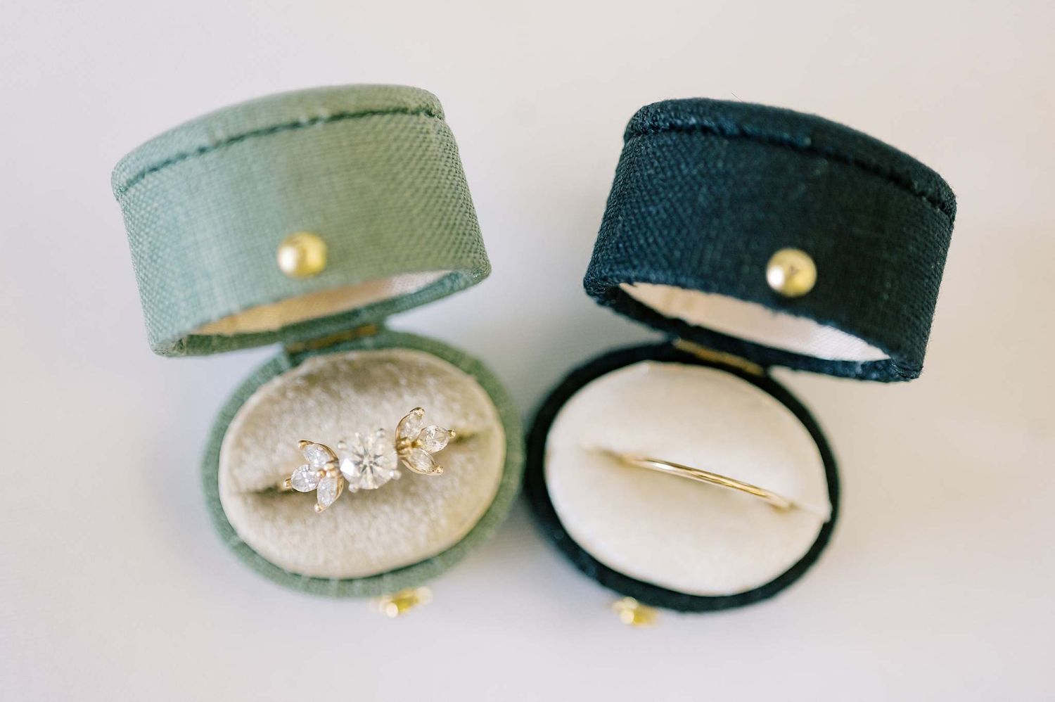 Collection of sage green velvet ring boxes photographed on white background.