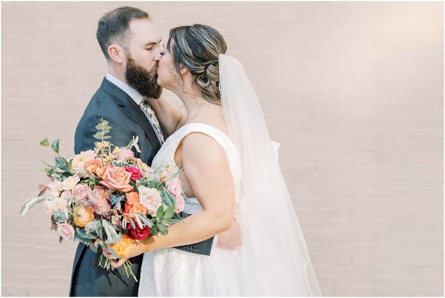Intimate wedding portrait with soft lighting and vibrant floral bouquet.