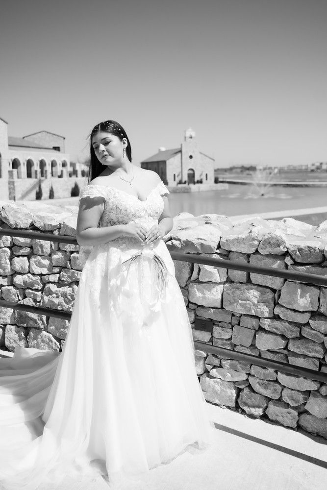 Black and white bridal portraits against a rustic stone wall with church architecture in background.