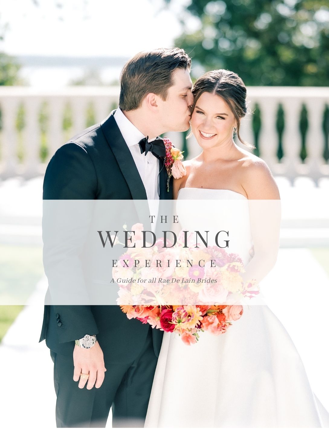 A bride and groom pose elegantly for The Wedding Experience guide cover, she holding a vibrant pink bouquet.