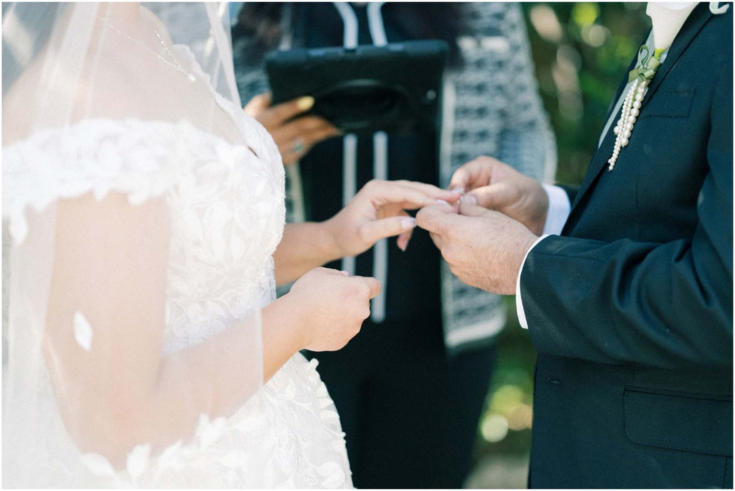 Wedding ceremony exchange of rings between couple in formal attire.