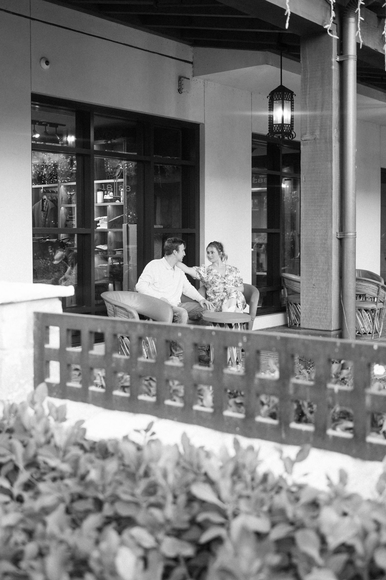 Black and white architectural detail of storefront with decorative railing.