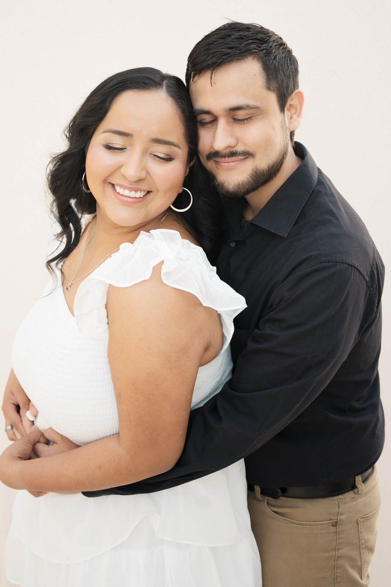 Intimate couple photos showing tender moments as they embrace in white and black attire.