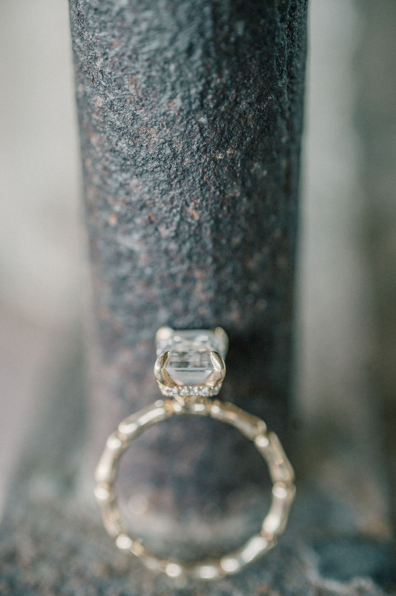 Detailed side view of a delicate diamond engagement ring band against a dark background.