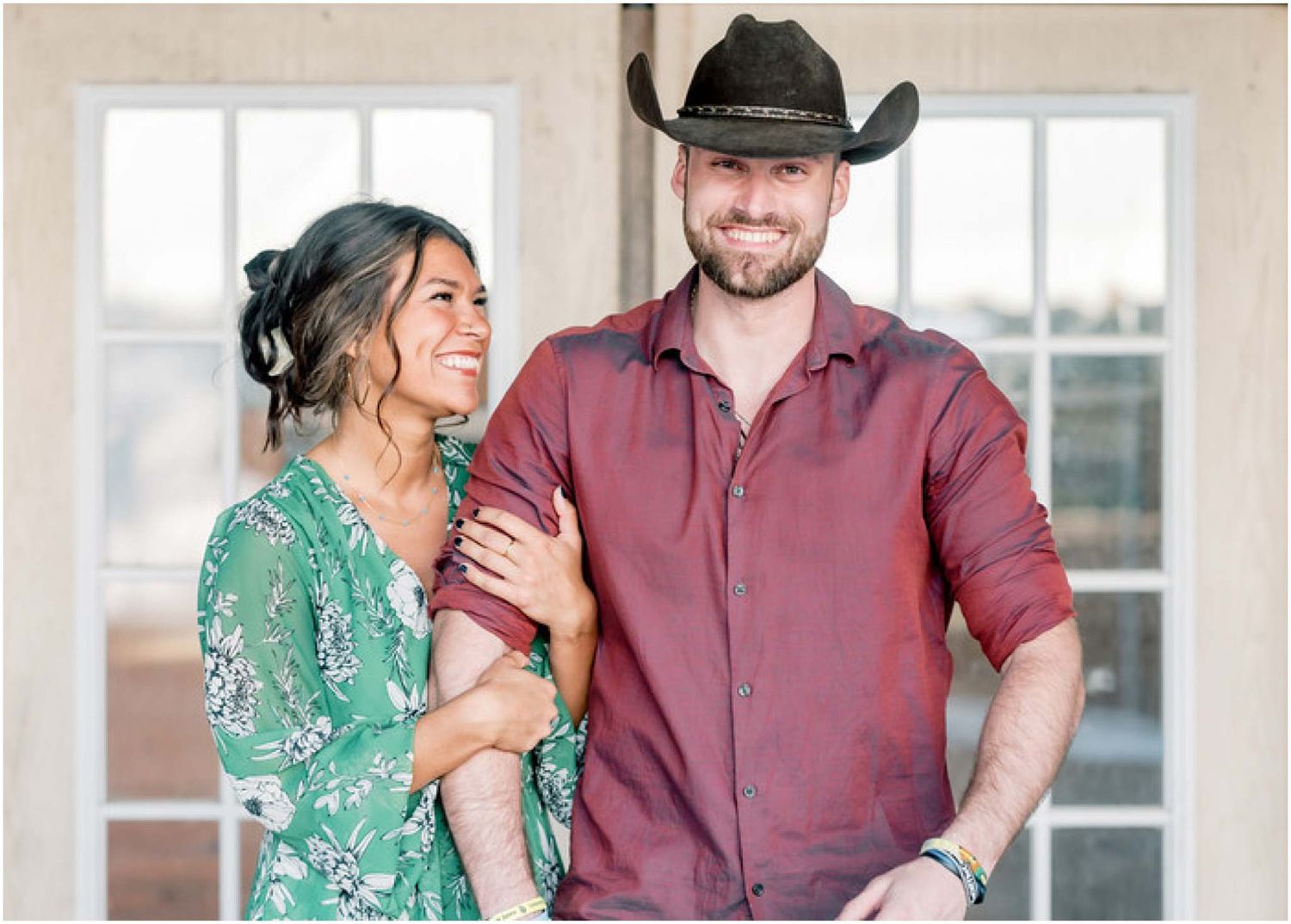 A couple in western attire sharing tender moments against a bright indoor setting.