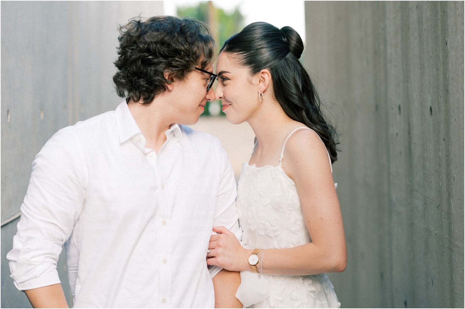 Intimate engagement photos showing couple embracing against neutral background.