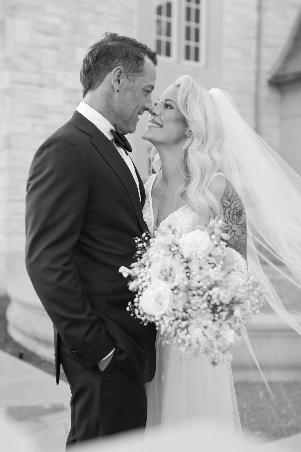 Black and white romantic wedding portrait showing tender moment between newlyweds.