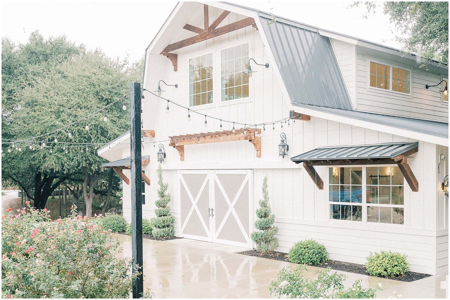 A collection of modern farmhouse-style buildings with white exterior walls and decorative trim details.