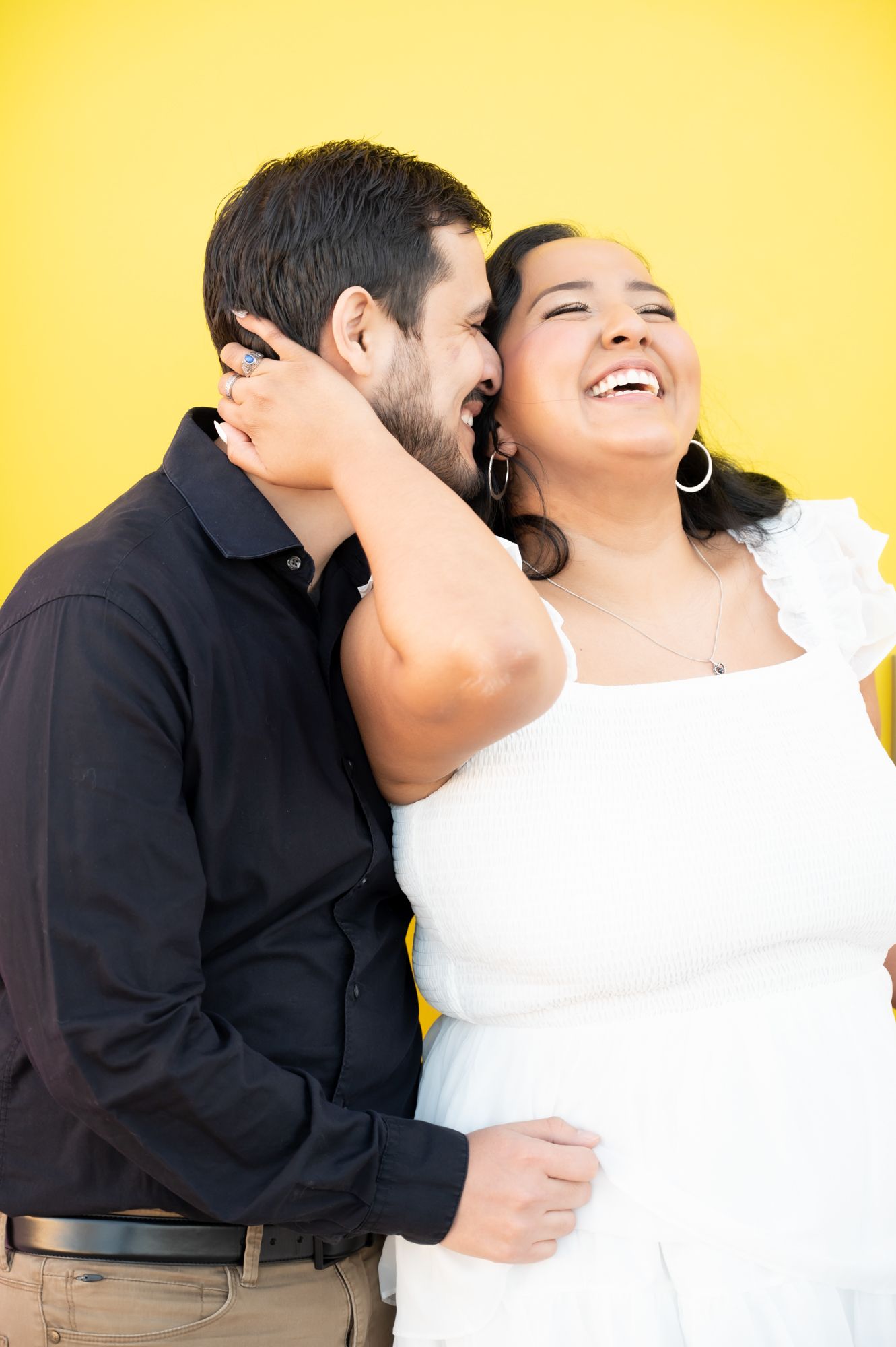 A romantic couple laughs together against a bright yellow background in a series of candid shots.