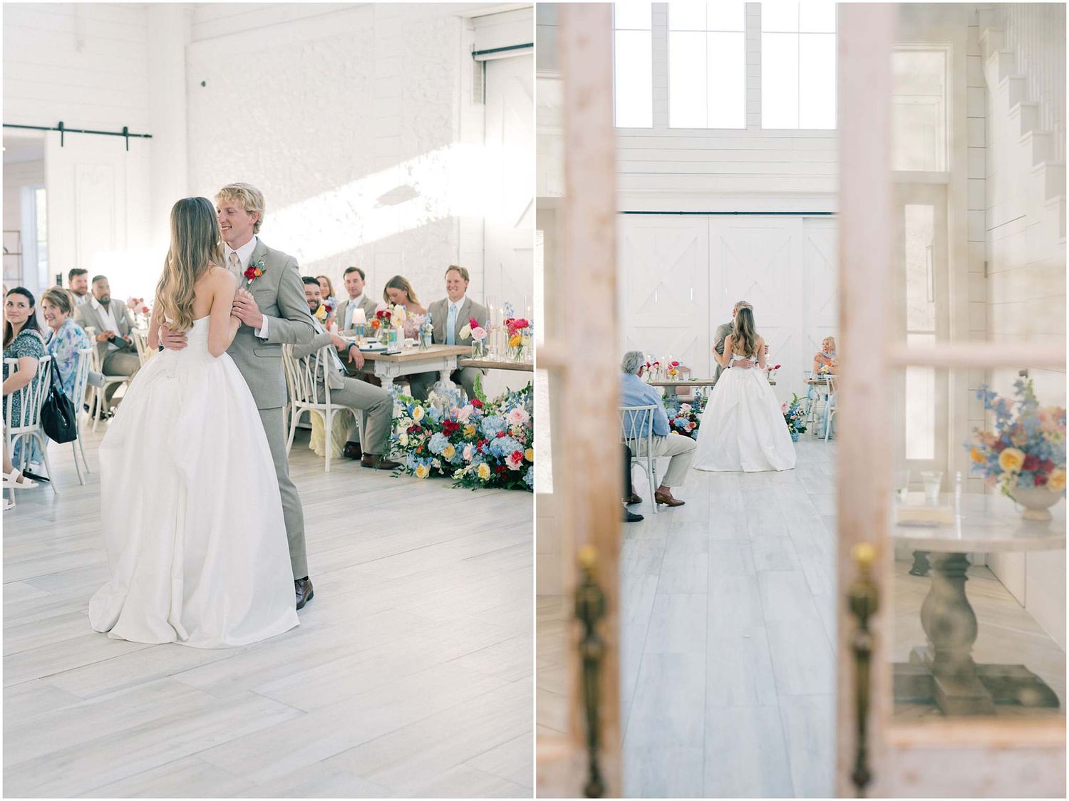 Bride and groom share their first dance in an elegant white reception hall surrounded by seated wedding guests.