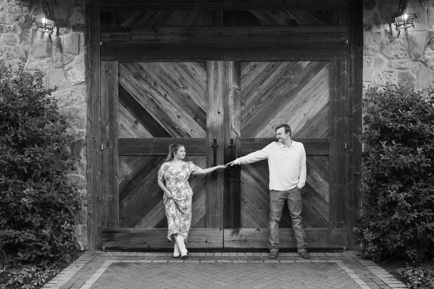 A series of black and white photos showing playful dance movements in front of a rustic wooden barn door.