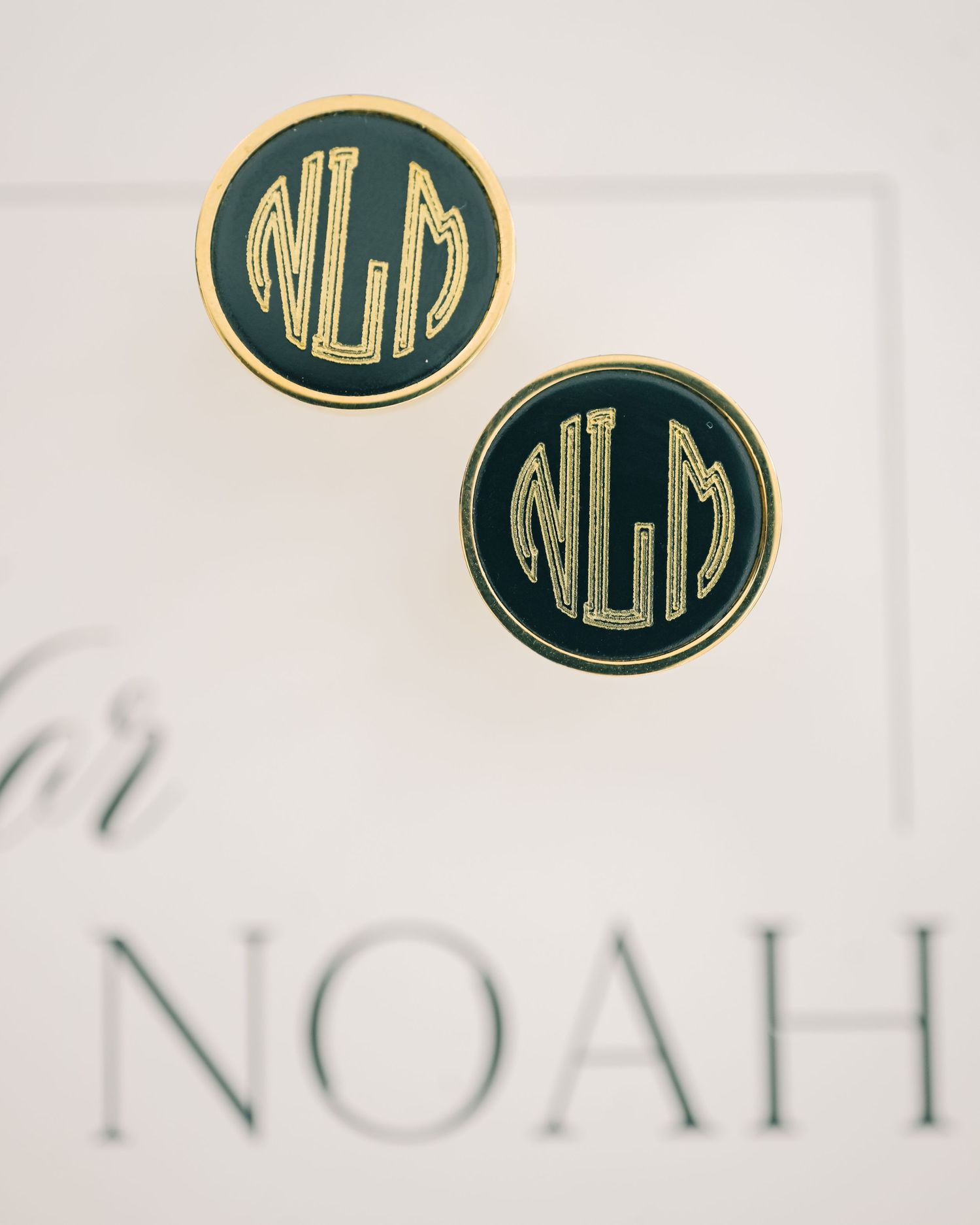 Gold and black monogram NLM cufflinks displayed on wedding stationery for groom Noah.