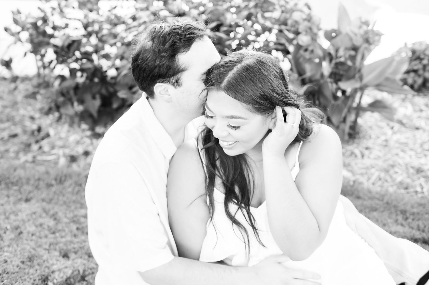 Intimate black and white portrait capturing a tender moment in a natural setting.