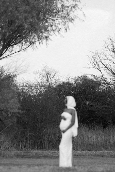 Black and white maternity photos showing silhouettes against a natural backdrop of trees and tall grass.