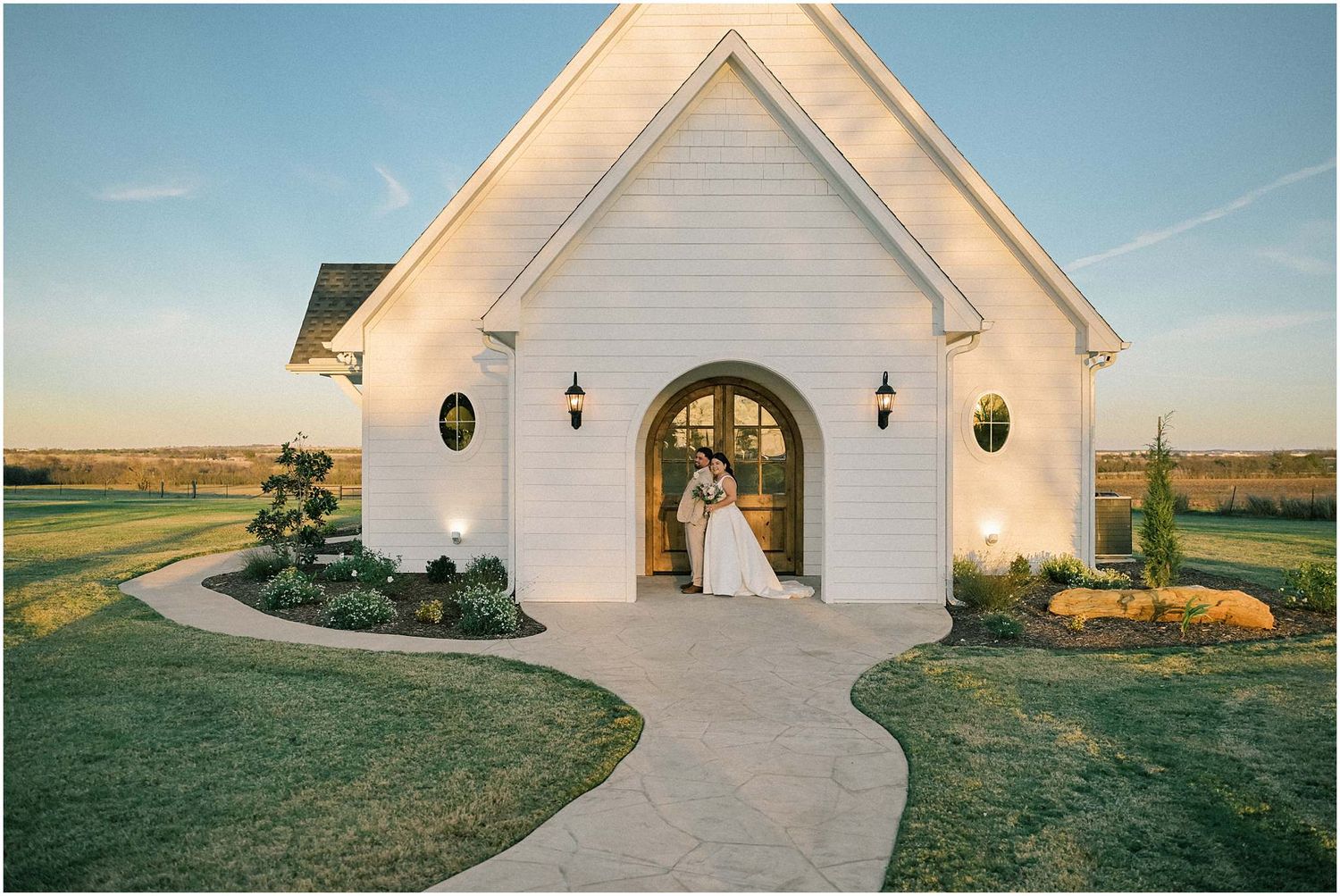 Scenic white chapel wedding venue with modern architectural details against blue sky.