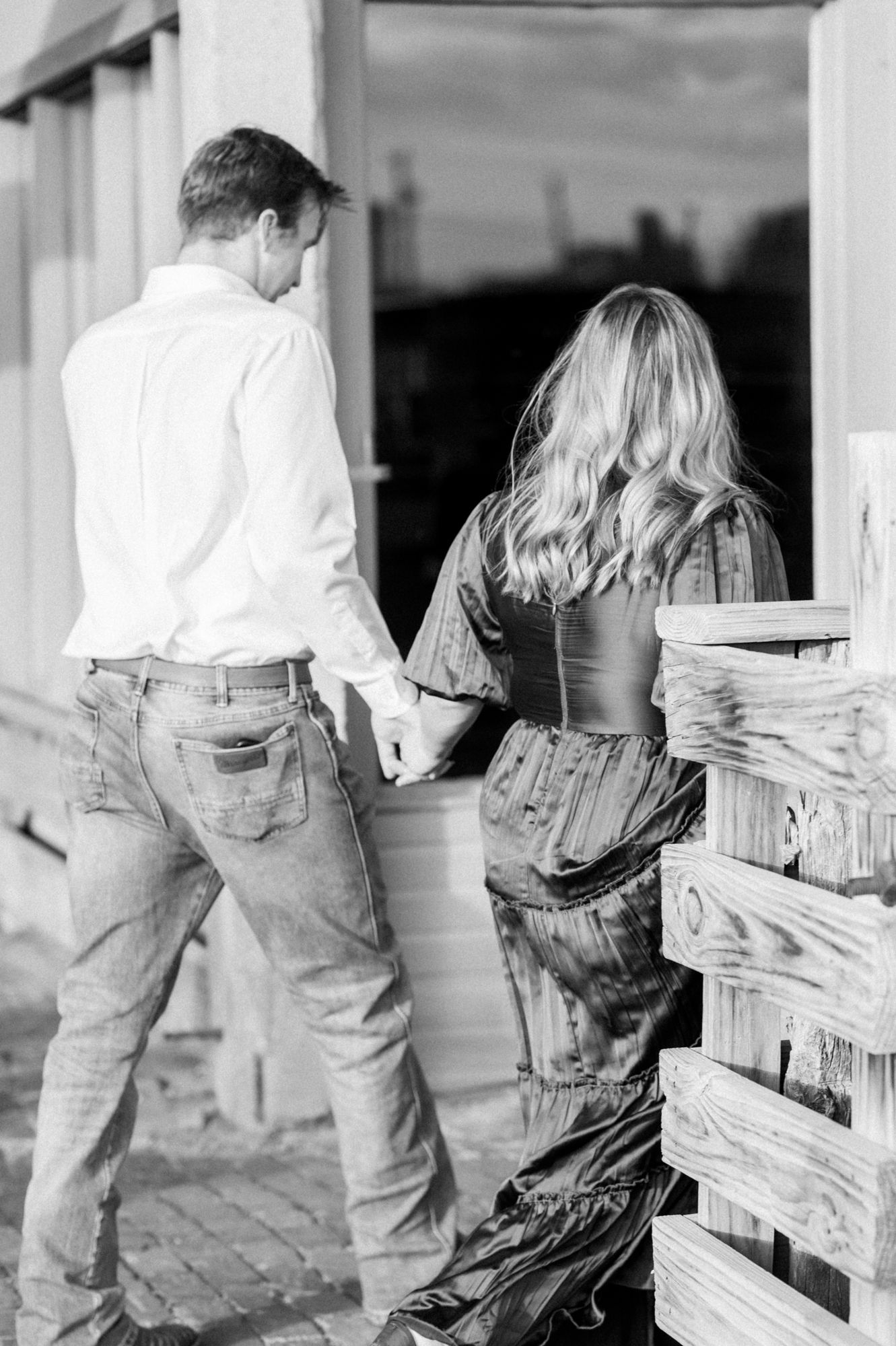 Black and white photos of a couple sitting together on wooden steps.