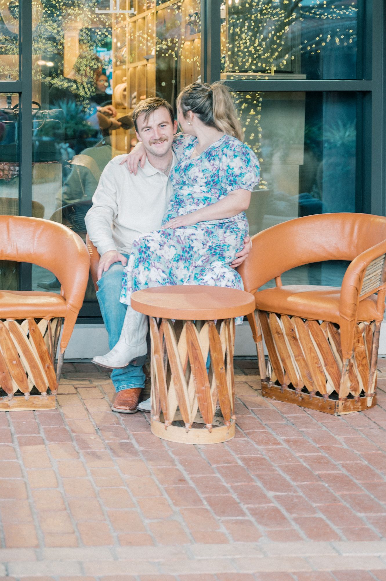 Romantic scene on outdoor patio with Mexican equipale chairs and warm ambient lighting.