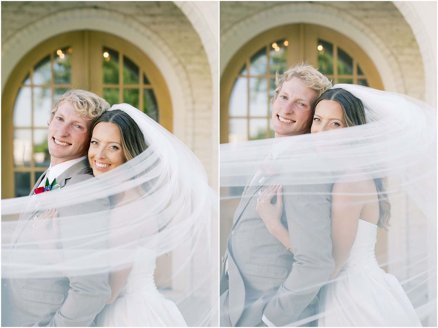 Bride and groom pose together wrapped in a flowing white wedding veil outdoors.