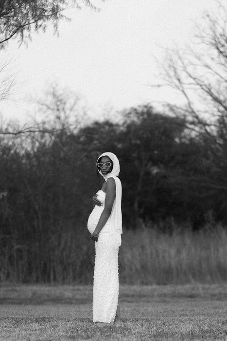 Dreamy black and white maternity photos captured in a serene field with trees.
