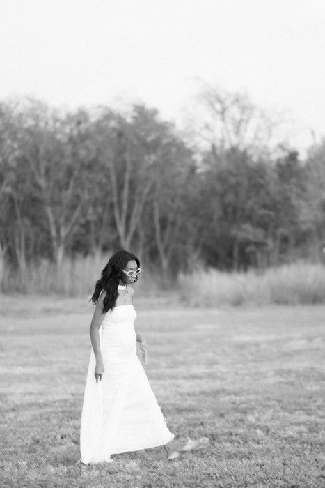 Artistic maternity photography with soft focus and natural outdoor elements.