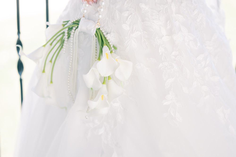 White lilies and floral arrangements accent a delicate bridal scene with soft lighting.