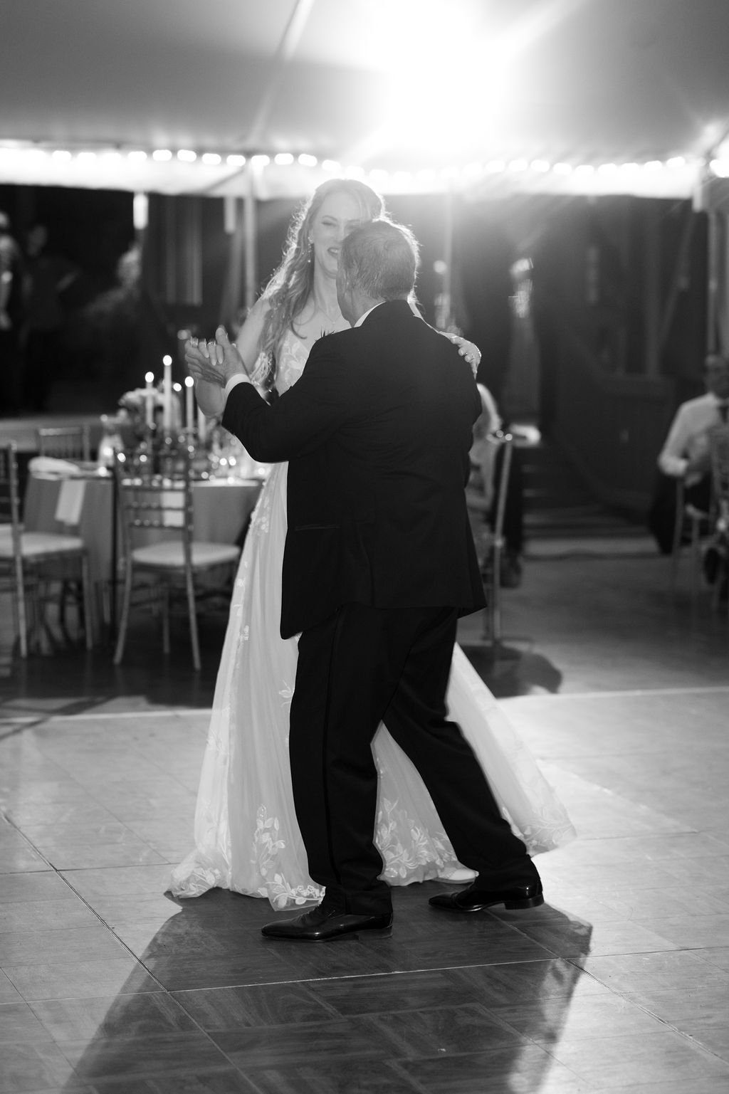 Black and white photo of bride and groom sharing their first dance at elegant wedding reception.