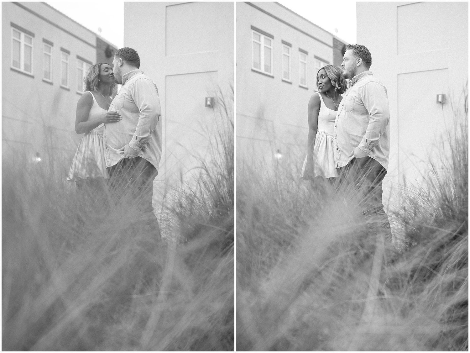 Romantic couple embracing in soft sunlight against white building exterior.