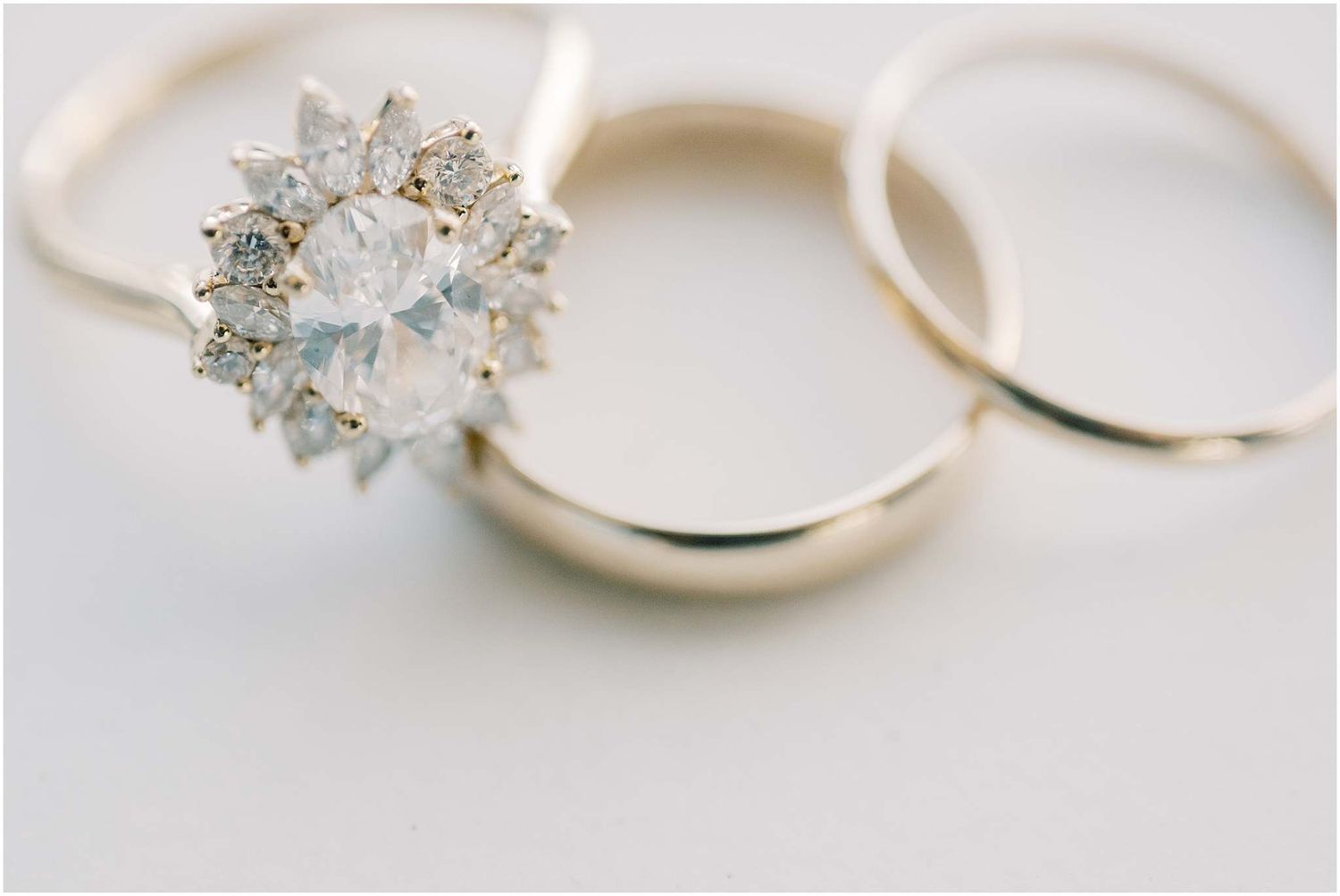 Close-up details of diamond engagement rings with delicate settings on white background.