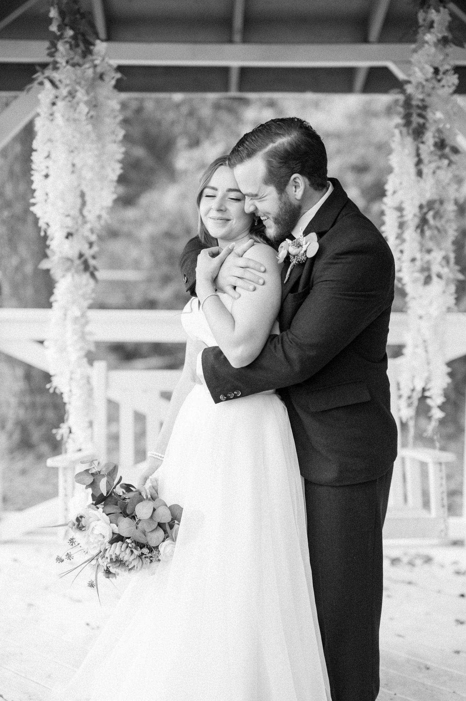 Black and white wedding photos showing tender moments under floral-decorated gazebo.