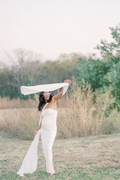 Expressive dance-like poses with billowing white fabric in a natural outdoor environment.