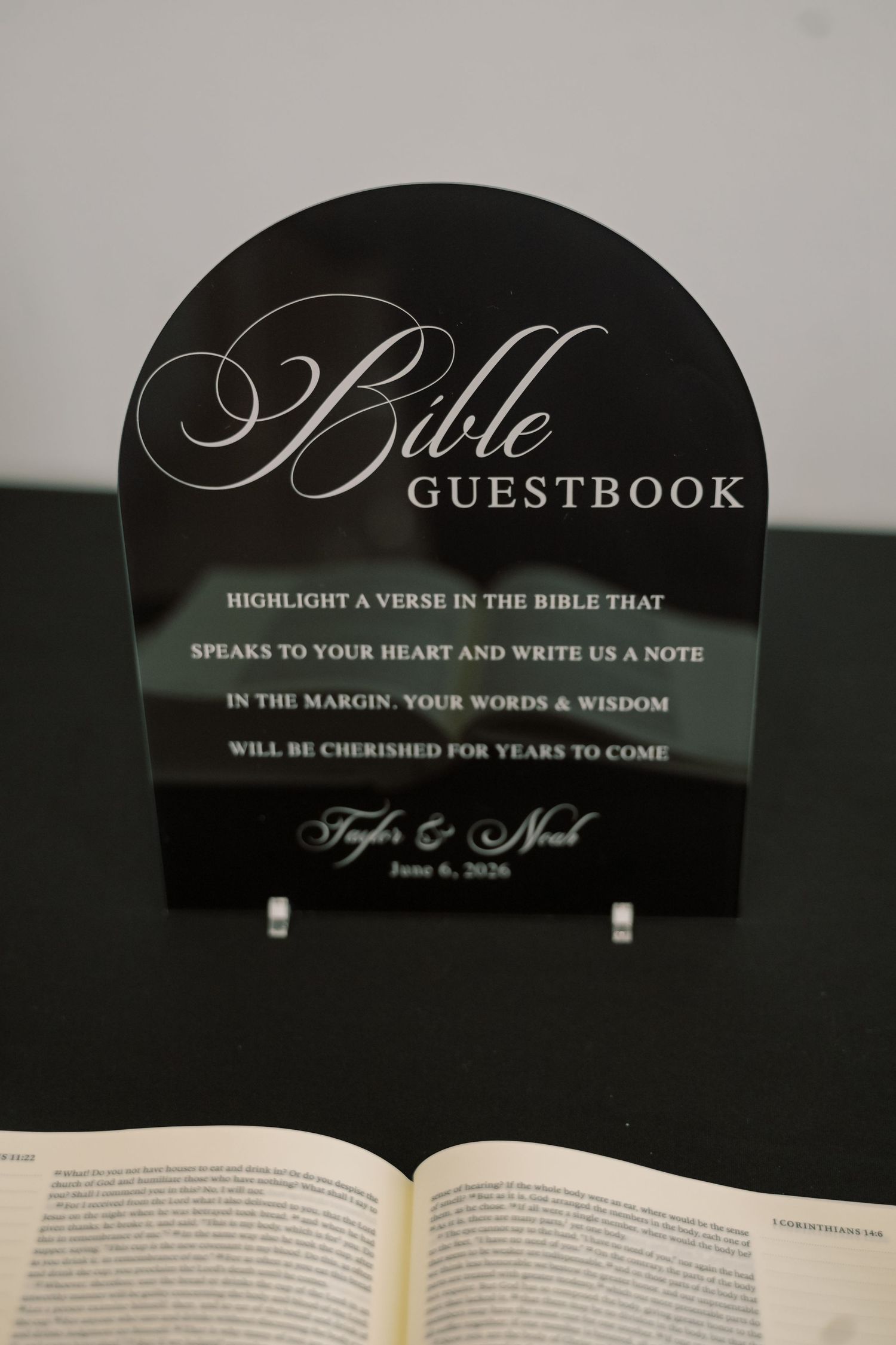 Black acrylic Bible guestbook sign for Taylor and Noah's June 6, 2026 wedding.