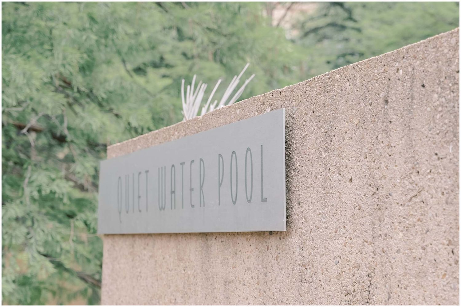 Modern architectural signage on textured concrete wall.