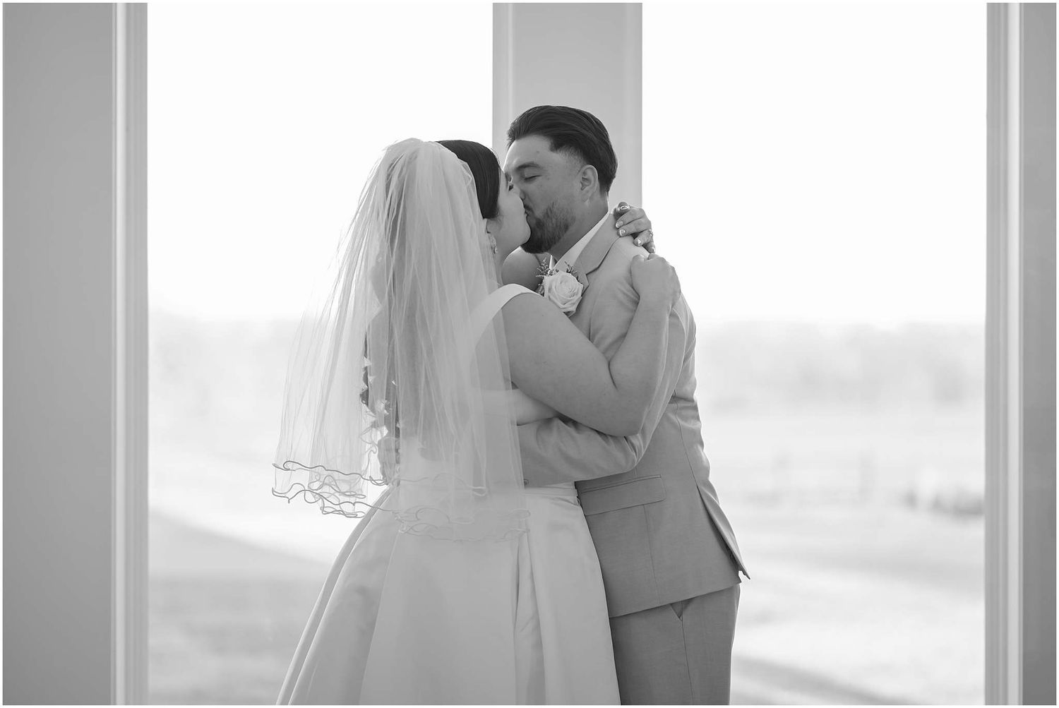 Romantic black and white wedding portraits captured in front of bright windows.