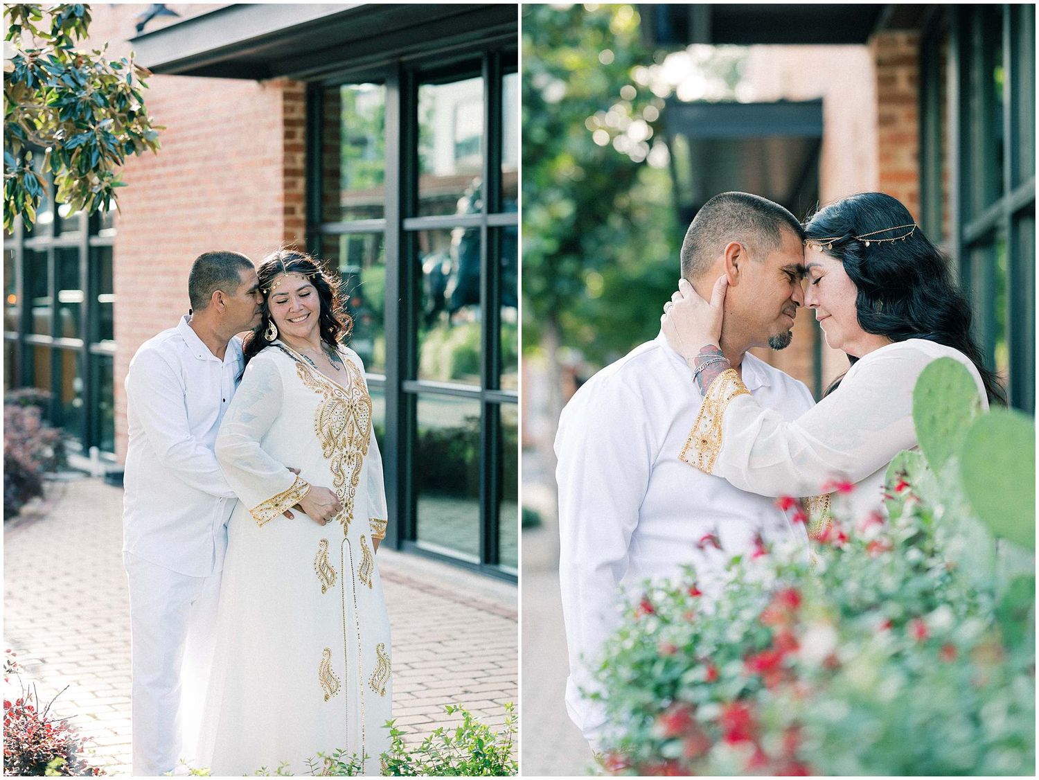 A couple in elegant white attire poses together near garden flowers.