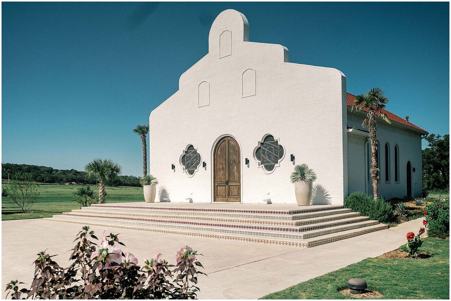 Architectural details of a white Spanish-style church exterior with steps and crosses.