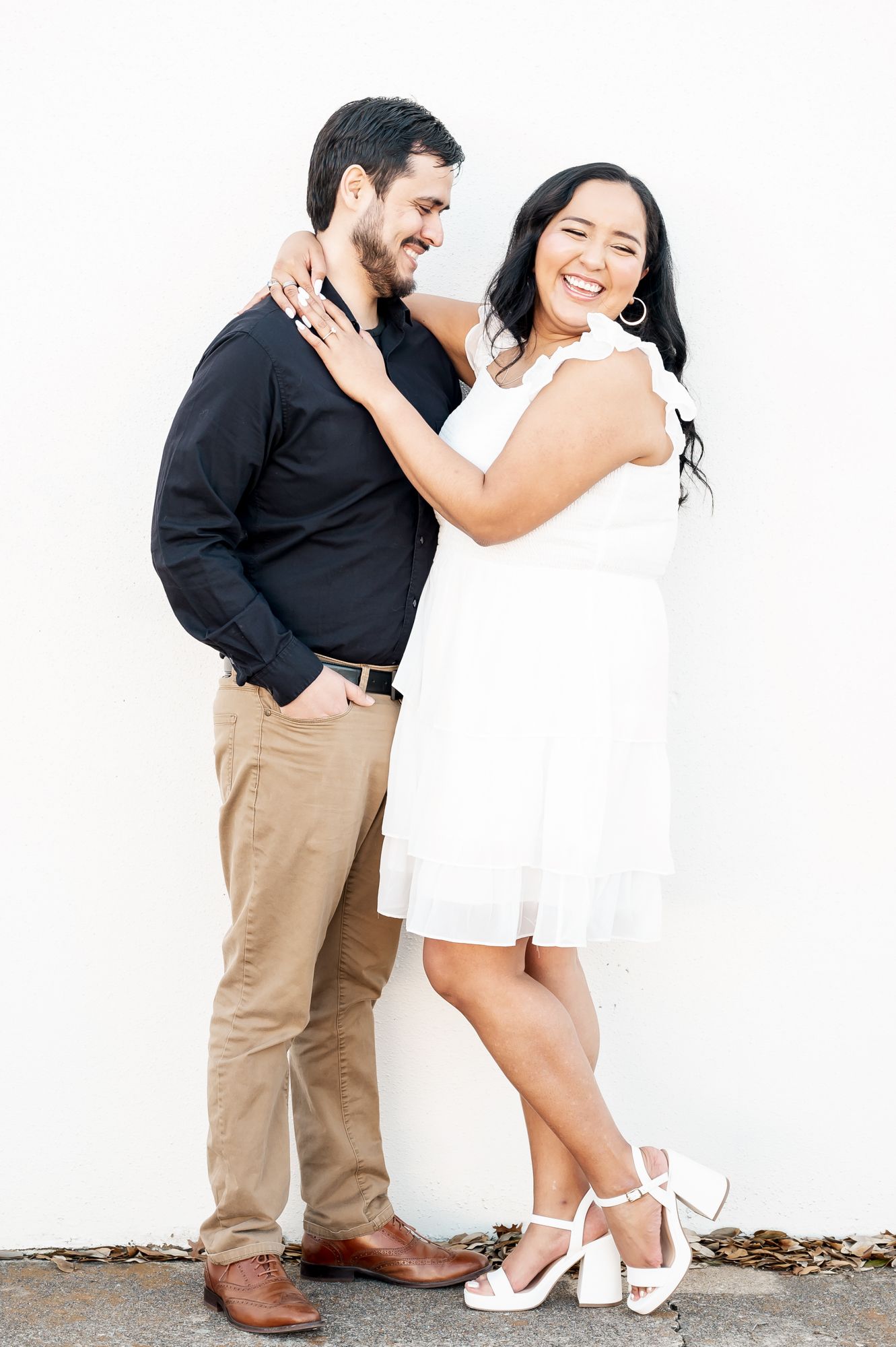A couple shares intimate moments in an outdoor photoshoot wearing coordinated black and white outfits.