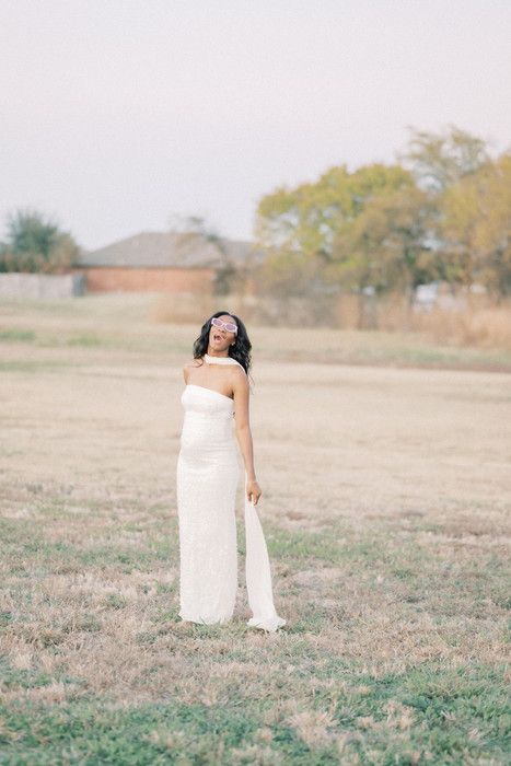 Ethereal outdoor photography featuring a person in white fabric standing in an open field.