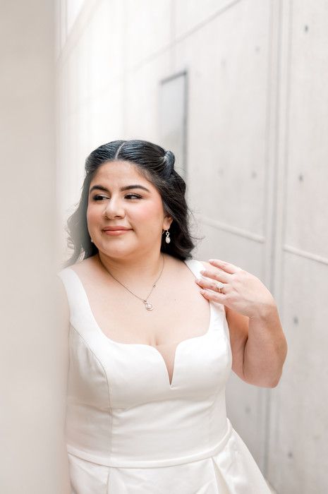 Close-up of smiling bride in white sweetheart neckline gown with jewelry.