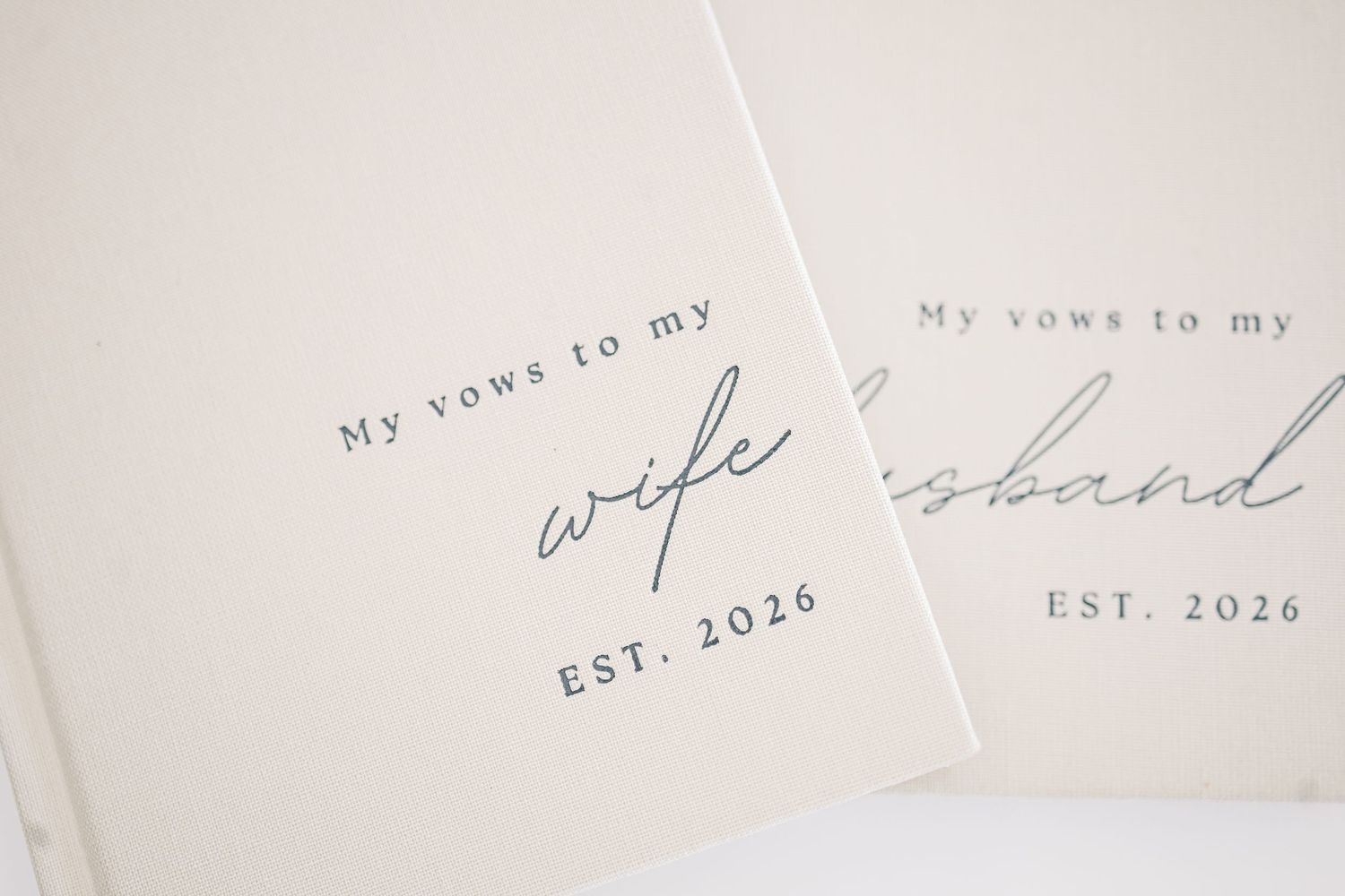 Two cream vow books reading My Vows to My Wife and My Vows to My Husband, EST. 2026.